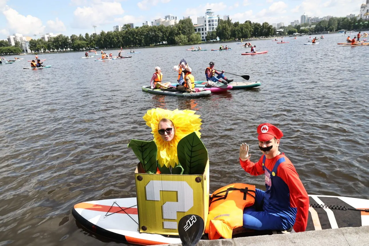 В Екатеринбурге прошёл фестиваль E1 SUP FEST: более тысячи участников в карнавальных костюмах вышли на городской пруд на сапбордах — от пиратов и балерин до лягушек и супергероев.