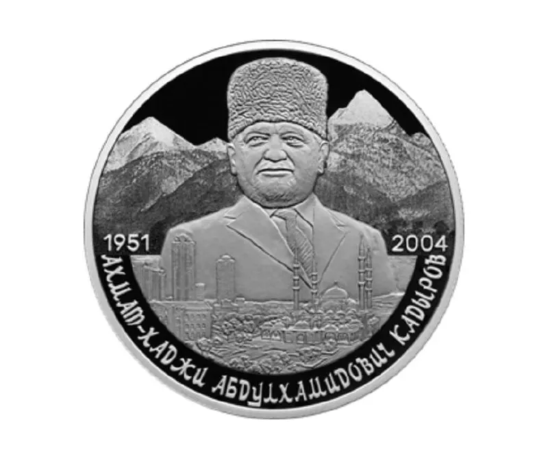 Памятная монета номиналом 2 рубля из серебра 925‑й пробы с изображением портрета Ахмата Кадырова на фоне Кавказских гор и города Грозный.