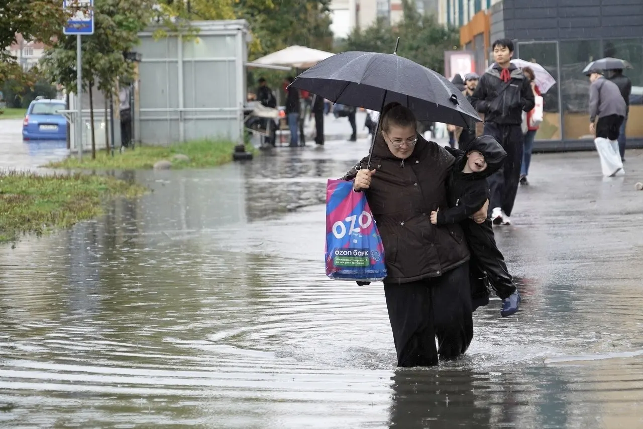 Из-за мощного ливня в городе образуются подтопления: пешеходы переходят улицы вброд, движение транспорта нарушено.